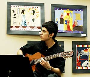 PHOTO: Joy Zelada plays guitar in Orange Hall Gallery