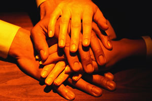 pile of hands showing unity