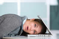 Lady with her head in a lap top